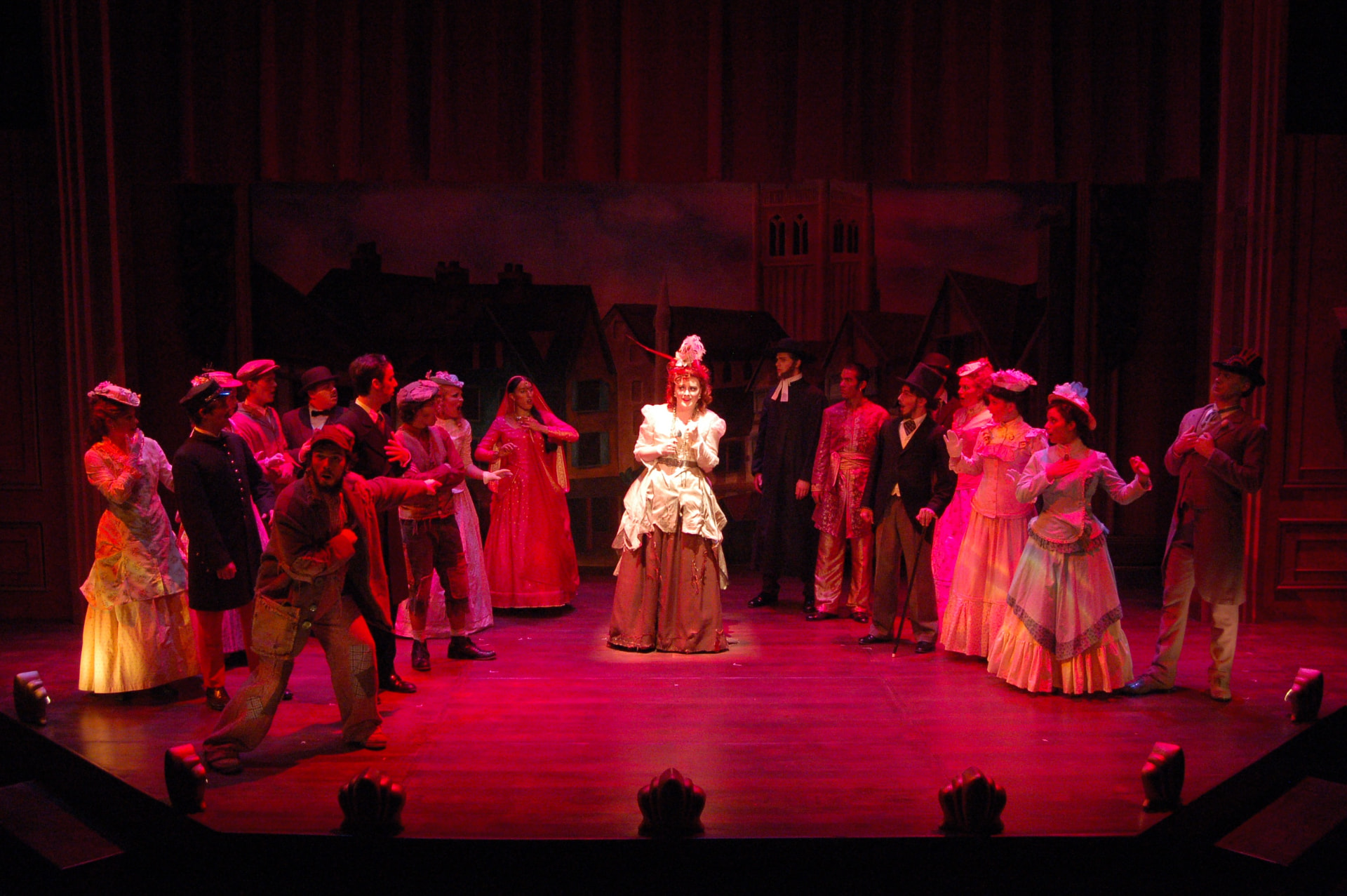 The Mystery of Edwin Drood — the company surrounding Edwin in a deep red wash