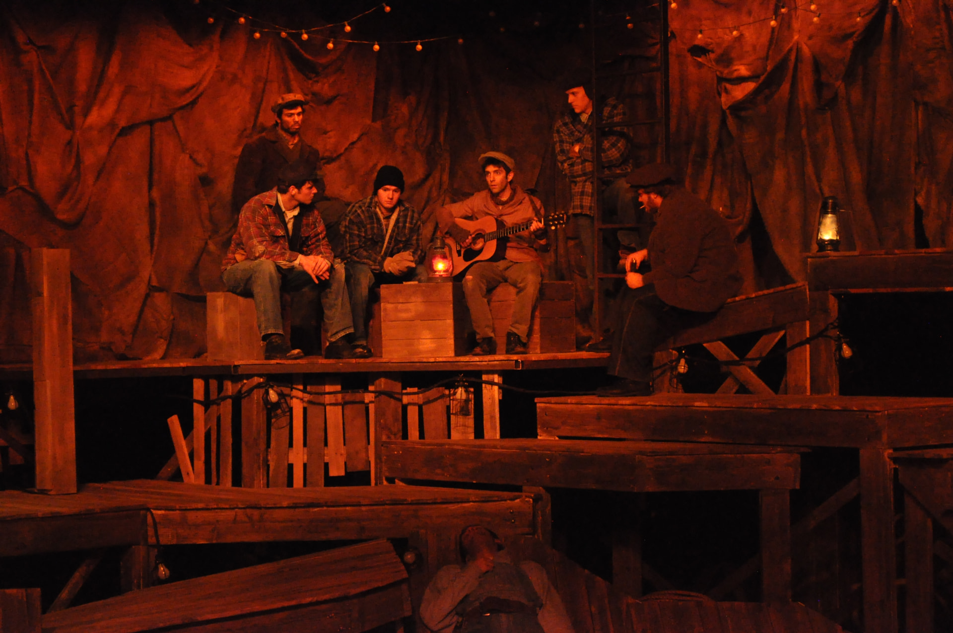 Floyd Collins — the men gathered around a guitar in warm firelight