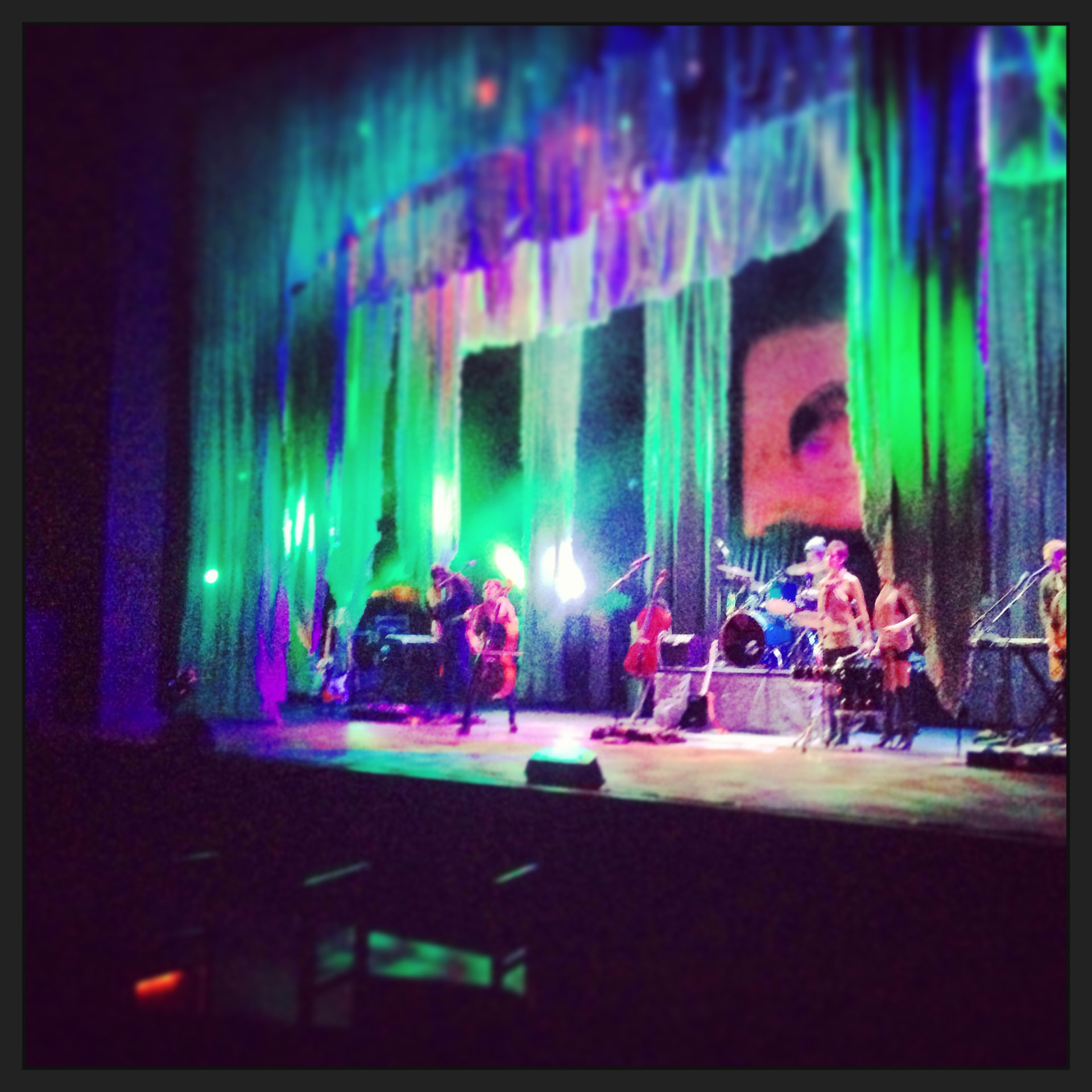 Medea — vivid green and purple stage with band and projected face